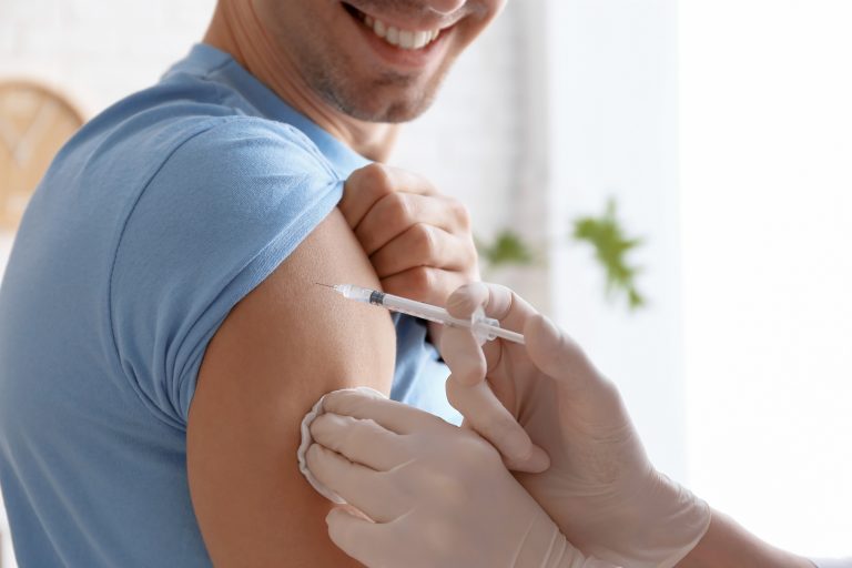 Doctor,Vaccinating,Male,Patient,In,Clinic,,Closeup