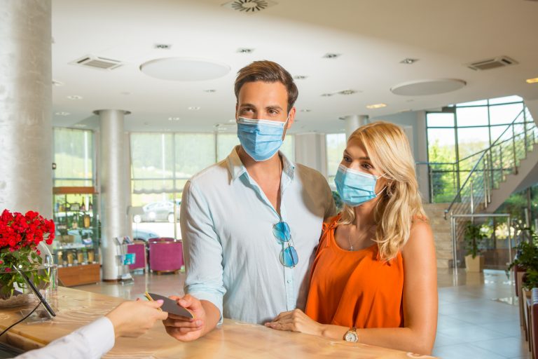 Young,Couple,Wearing,Protective,Mask,Check,In,At,Hotel,Reception