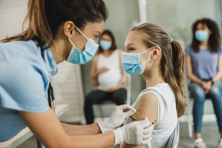 A,Nurse,Applying,A,Adhesive,Patch,To,A,Cute,Teenager