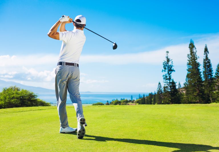 Golfer,Hitting,Ball,With,Club,On,Beatuiful,Golf,Course