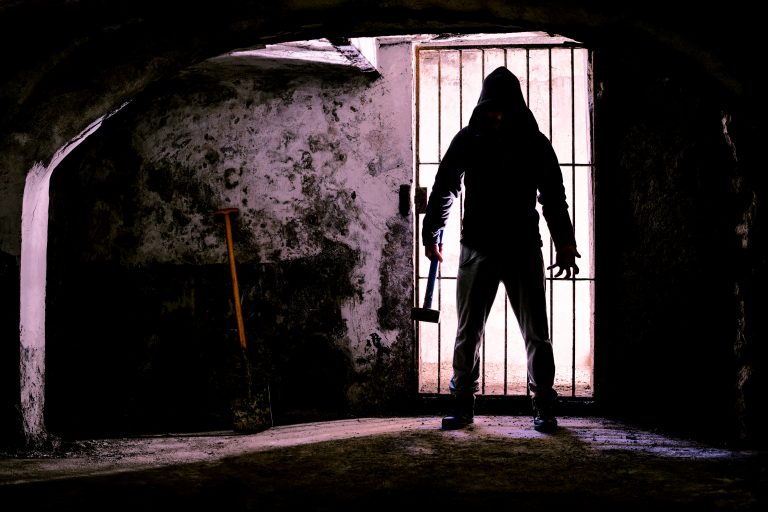 Scary,Dark,Man,Holding,Hammer,Inside,Dungeon,-,Silhouette,Of
