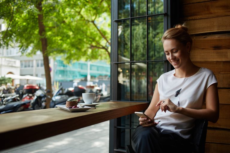 Charming,Woman,With,Beautiful,Smile,Reading,Good,News,On,Mobile