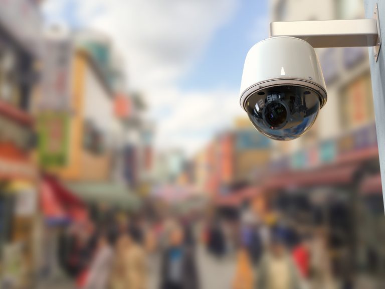 3d,Rendering,Security,Camera,Or,Cctv,Camera,With,Cityscape,Background