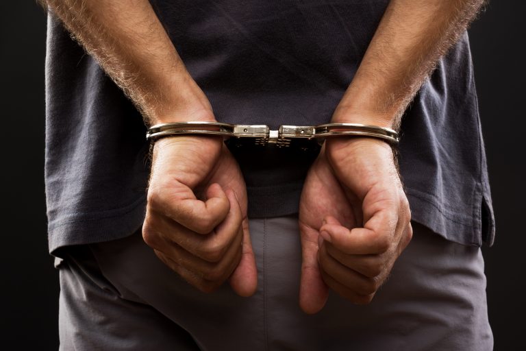 Close-up.,Arrested,Man,Handcuffed,Hands,At,The,Back