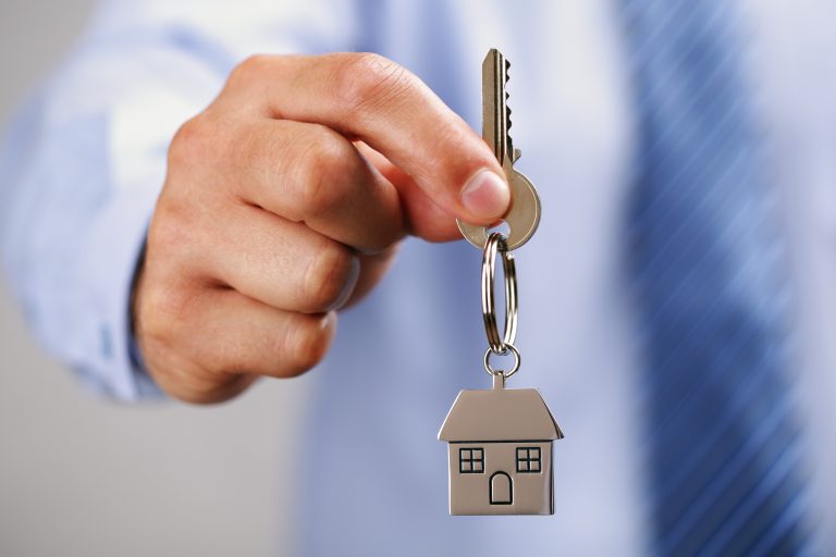 Holding,Out,House,Keys,On,A,House,Shaped,Keychain