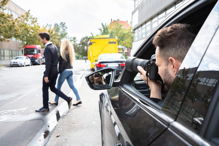 Private,Detective,Taking,Photos,Of,Man,And,Woman,On,Street