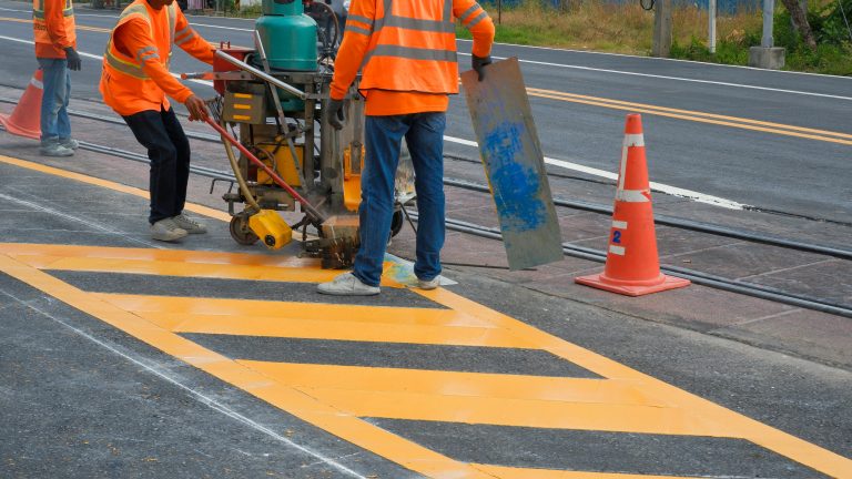 Road,Workers,In,Reflective,Vests,With,Thermoplastic,Spray,Road,Marking