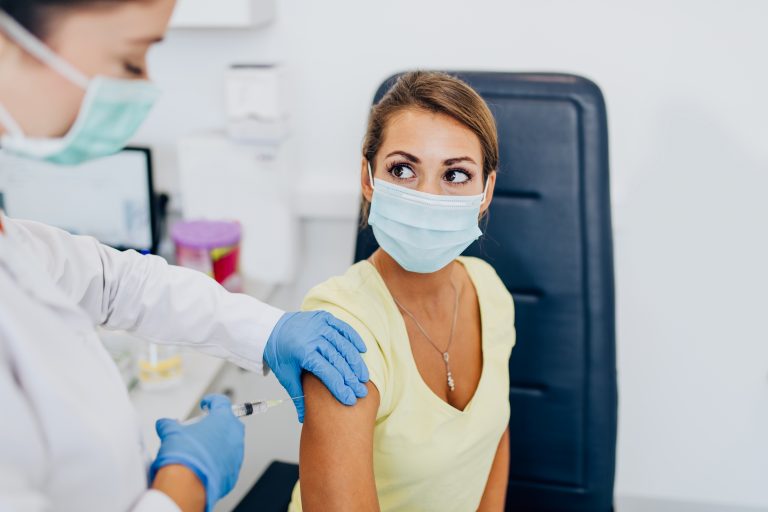 Female,Doctor,Or,Nurse,Giving,Shot,Or,Vaccine,To,A