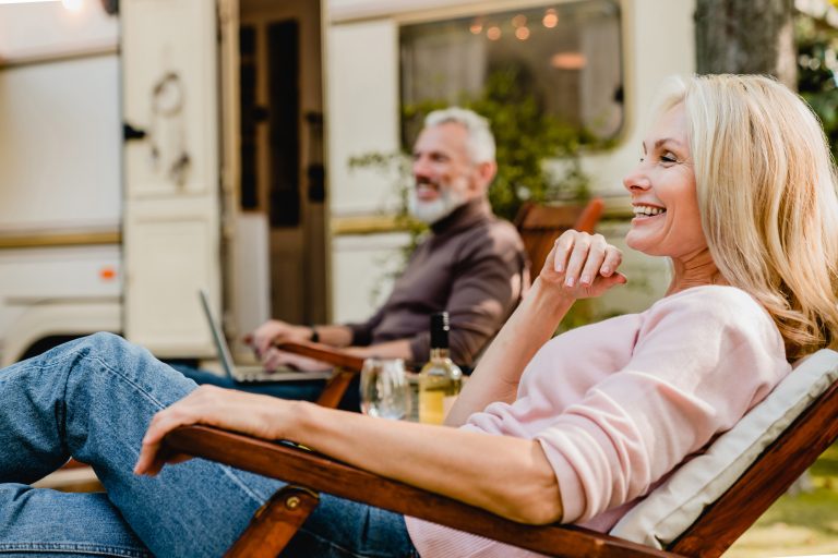 Mature,Couple,Relaxing,On,The,Deck,Chairs,Near,Their,Mobile