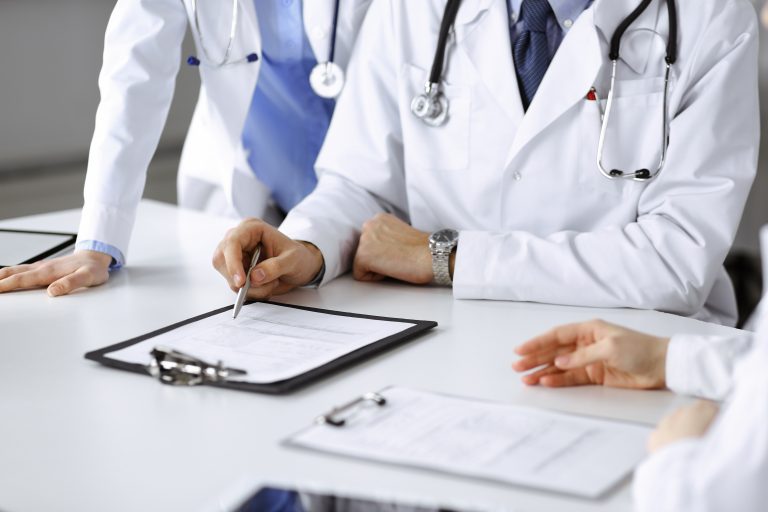 Group,Of,Unknown,Doctors,Are,Sitting,At,The,Desk,And