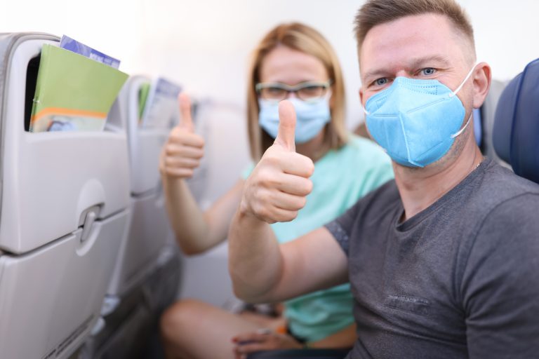 Man,And,Woman,In,Medical,Protective,Masks,In,Aircraft,Cabin