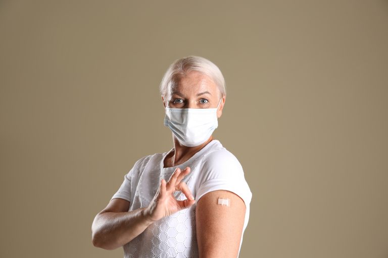 Mature,Woman,In,Protective,Mask,Showing,Arm,With,Bandage,After