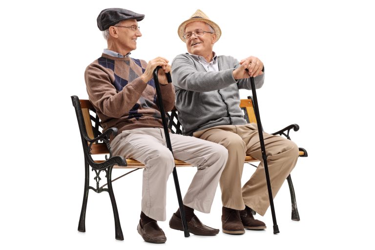 Two,Elderly,Men,Sitting,On,A,Wooden,Bench,And,Talking