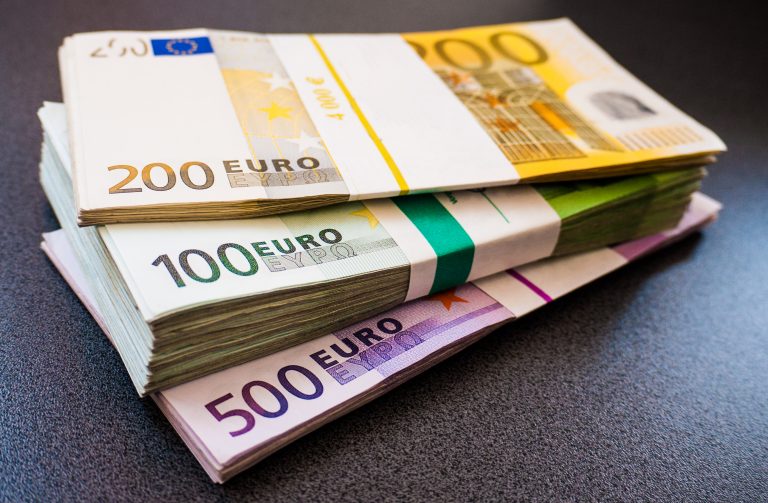 Stacks,Of,Euro,Notes,On,A,Dark,Desk,In,Five