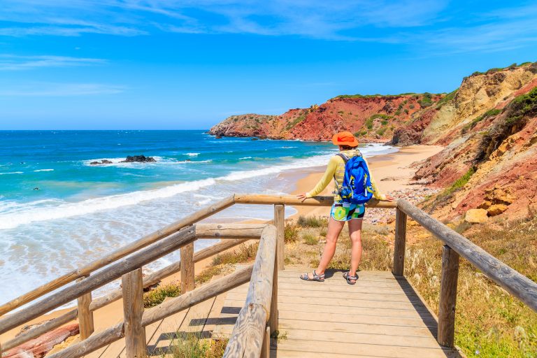 Young,Woman,Tourist,Looking,At,Amado,Beach,From,Wooden,Walkway,