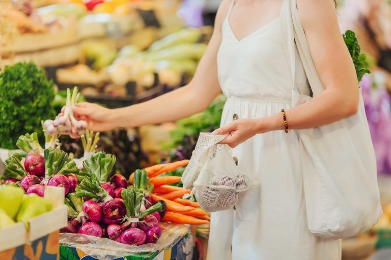 Young,Woman,Puts,Fruits,And,Vegetables,In,Cotton,Produce,Bag