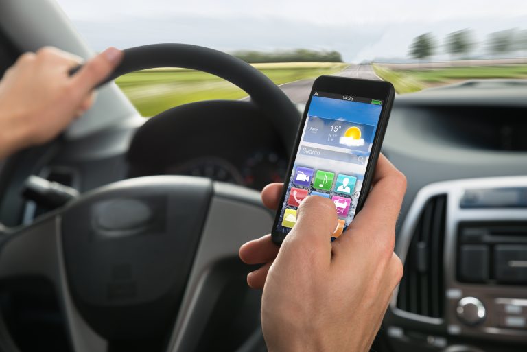 Close-up,Of,A,Person's,Hand,Using,Cellphone,While,Driving,A
