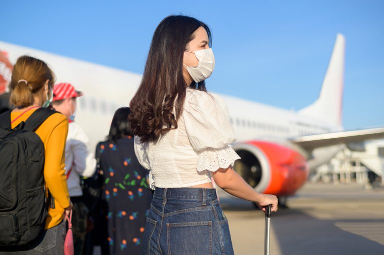 A,Young,Woman,Traveler,Wearing,Protective,Mask,Getting,In,Airplane