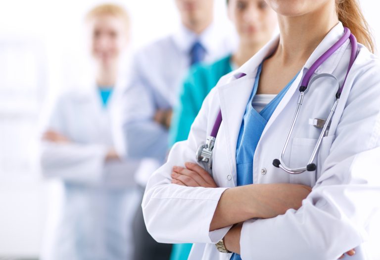 Attractive,Female,Doctor,In,Front,Of,Medical,Group,.