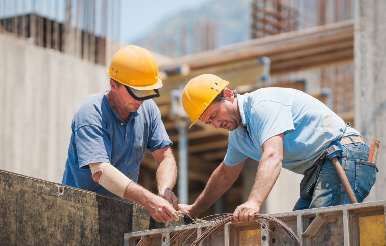 Construction,Workers,Collaborating,In,The,Installation,Of,Cement,Formwork,Frames