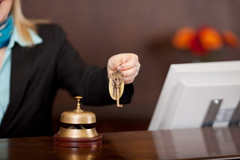 Receptionist,Passing,Room,Keys,Over,The,Counter