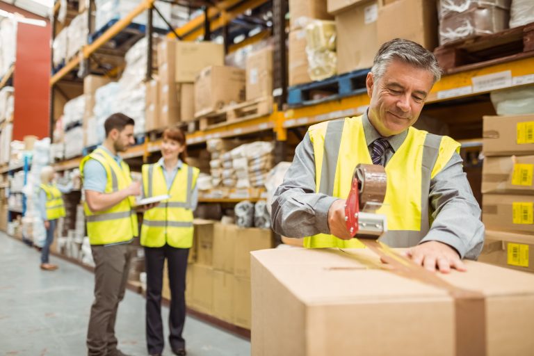 Warehouse,Worker,Sealing,Cardboard,Boxes,For,Shipping,In,A,Large