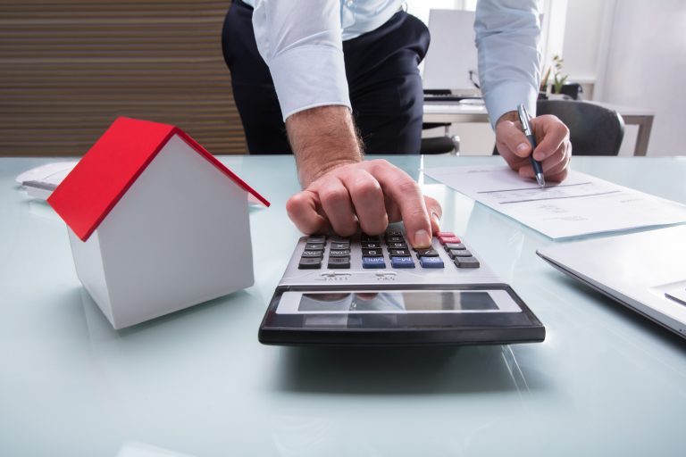 Human,Hand,Calculating,Bill,Using,Calculator,With,House,Model,On