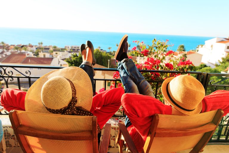 Happy,Couple,Relax,On,Balcony,Terrace,,On,Vacation,In,Europe