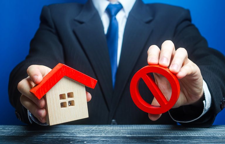 A,Man,Holds,A,House,And,The,Red,Prohibition,Symbol