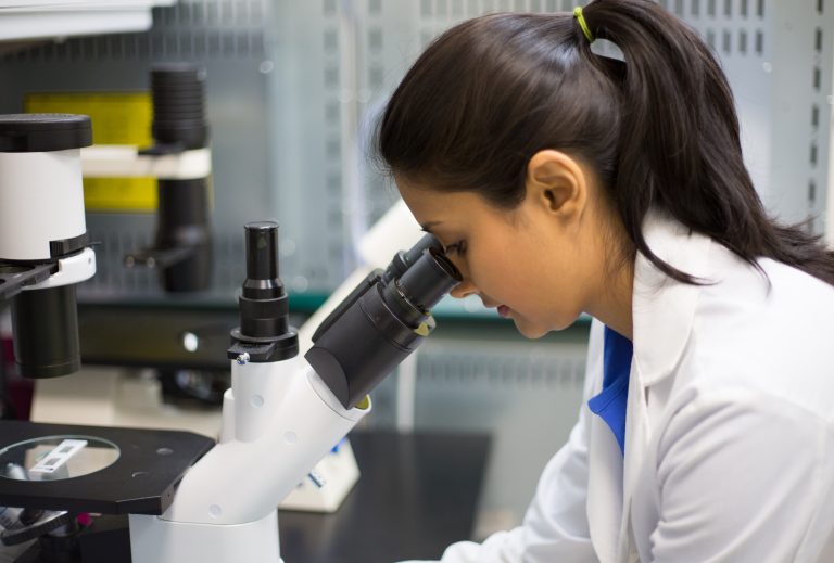 Closeup,Portrait,,Young,Scientist,Looking,Into,Microscope.,Isolated,Lab,Background.