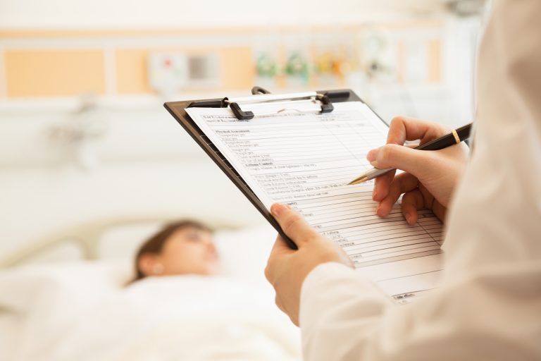 Close,Up,Of,Doctor,Writing,On,A,Medical,Chart,With