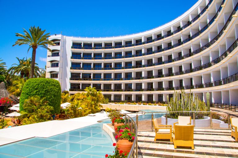 Luxury,Hotel,With,Infinity,Pool,And,Palms,All,Around,It.