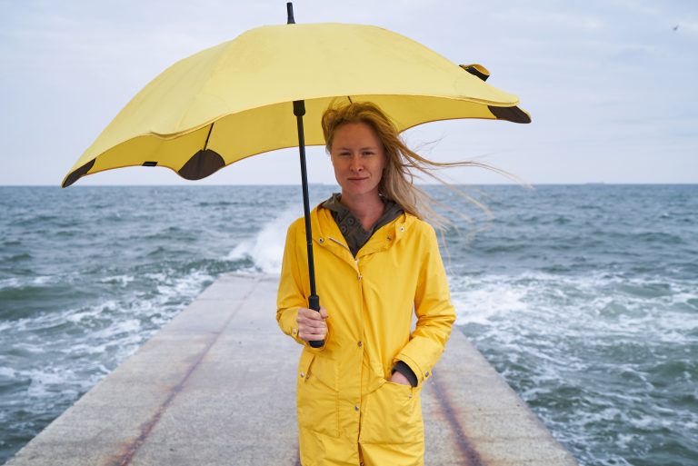 Young,Female,In,Yellow,Raincoat,And,With,Yellow,Umbrella,Standing