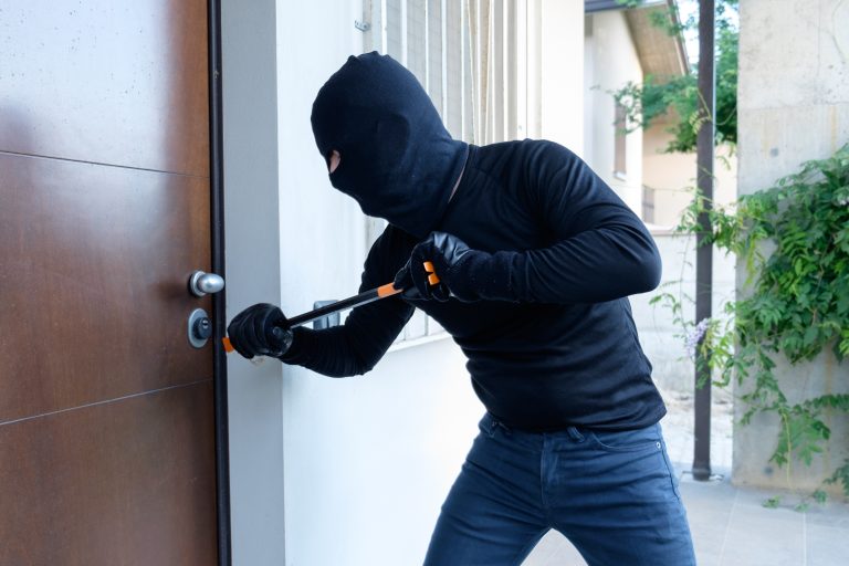 Burglar,Trying,To,Force,A,Door,Lock,Using,A,Crowbar
