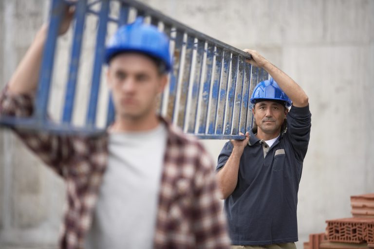 Closeup,Of,Two,Construction,Workers,Carrying,Ladder