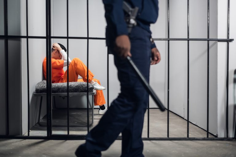 A,Male,Warden,Guards,Cells,With,Dangerous,Criminals,In,A