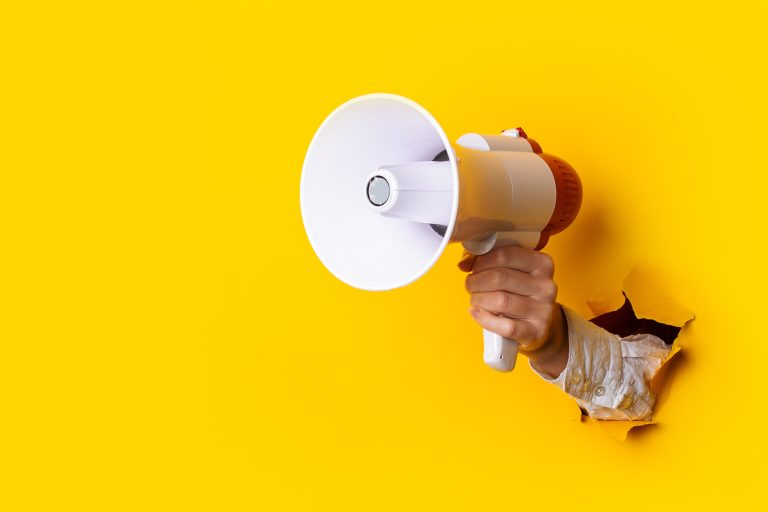 Hand,Holds,A,Megaphone,From,A,Hole,In,The,Wall