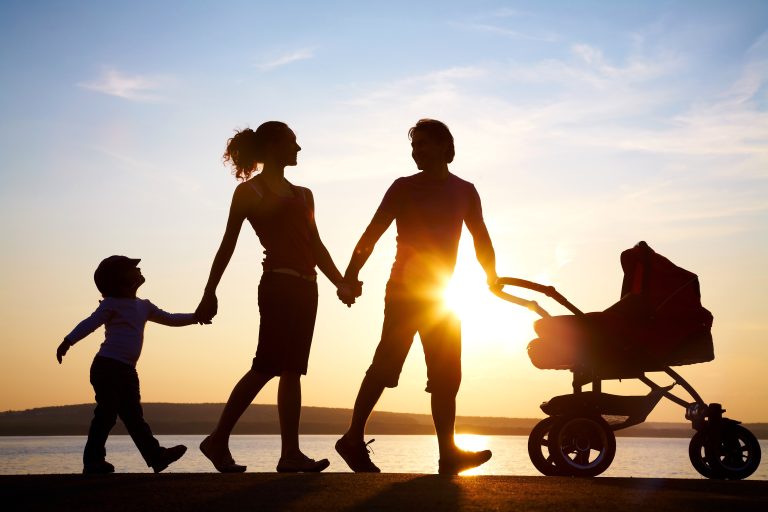 Silhouettes,Of,Happy,Parents,Walking,With,Child,And,Baby's,Stroller