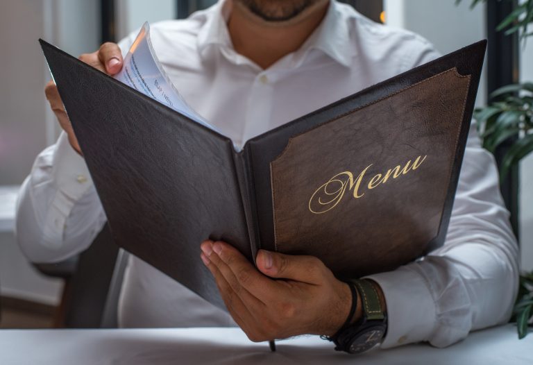Man,Reading,A,Restaurant,Menu,Card