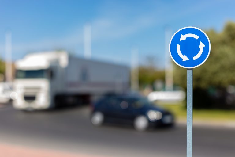 A,White,Blue,Sign,With,Arrows,Shows,A,Roundabout,In