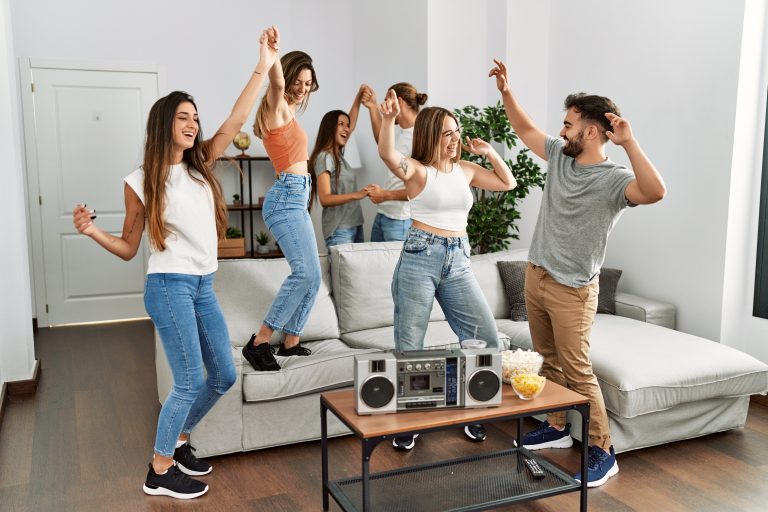 Group,Of,Young,Friends,Smiling,Happy,And,Dancing,At,Home.