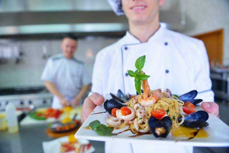 Handsome,Chef,Dressed,In,White,Uniform,Decorating,Pasta,Salad,And
