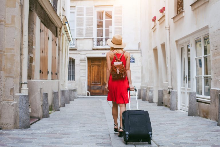Travel,Background,,Woman,Tourist,Walking,With,Suitcase,On,The,Street