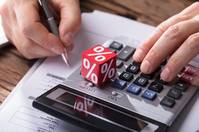 Close-up,Of,A,Dice,Showing,Percentage,Symbol,While,Businessperson,Using