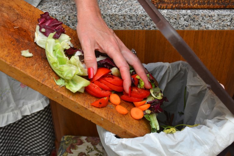 Detail,Of,A,Female,Hand,Throwing,Organic,Waste,In,A