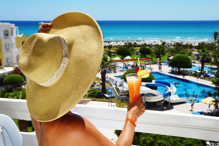 Woman,With,Drink,On,The,Balcony,In,A,Tourist,Resort.