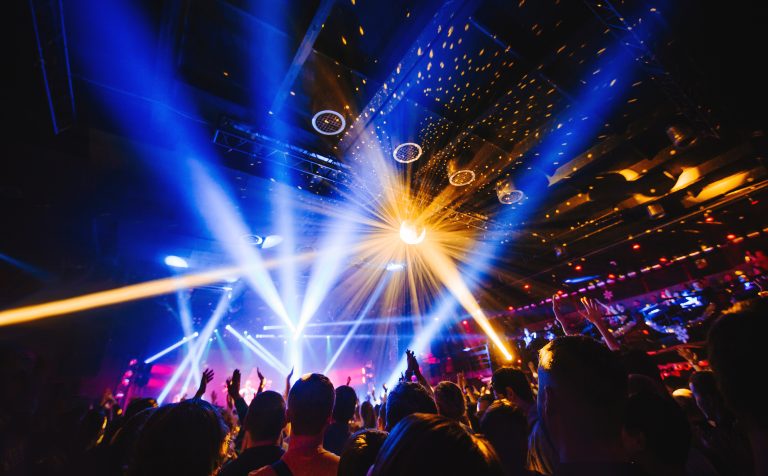 Silhouette,Of,Concert,Crowd,In,Front,Of,Bright,Stage,Lights.
