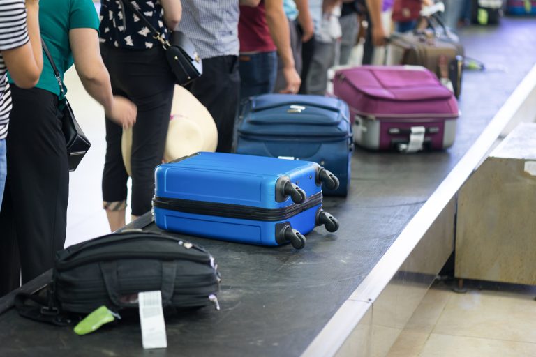 Suitcase,On,Luggage,Conveyor,Belt,At,Baggage,Claim,At,Airport.