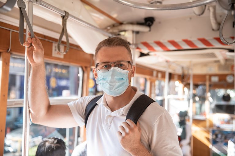Caucasian,Man,Student,On,Face,Medical,Mask,While,Traveling,Inside