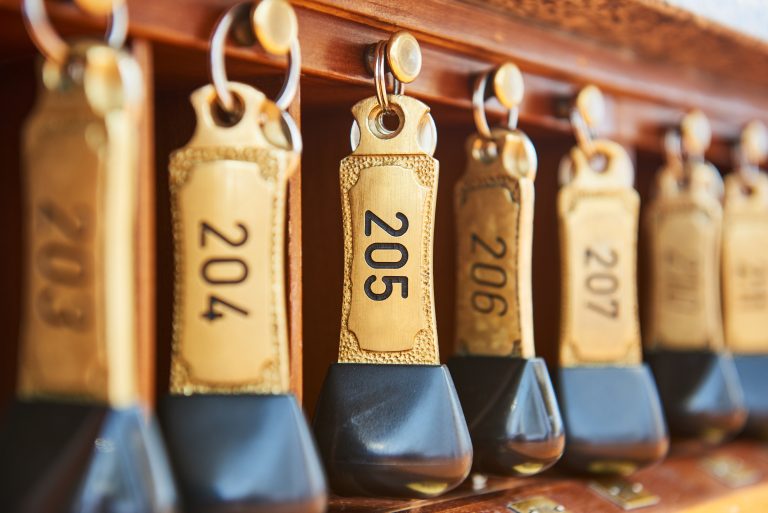 Hotel,Bronze,Keys,With,Room,Numbers,Hanging,At,Reception,Desk